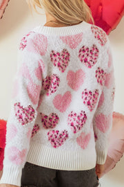Fuzzy white knit sweater with blush pink heart jacquard pattern and pearl embellishments.