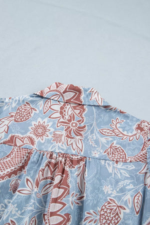Cotton button-up shirt with blue floral pattern and scalloped trim detail.