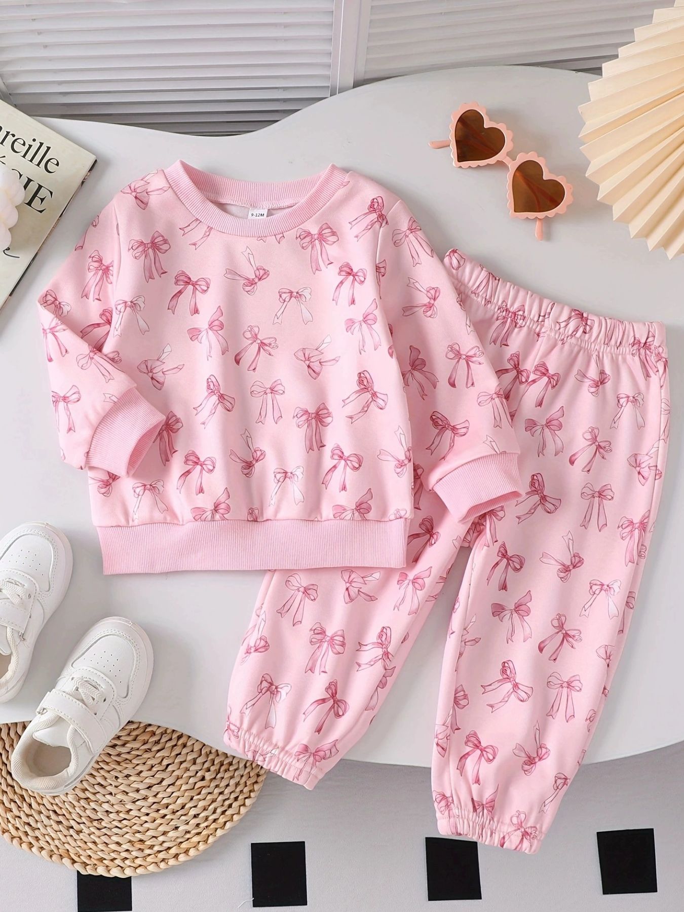 Pink baby set with allover bow print, crewneck long sleeve top and elastic waist pants.