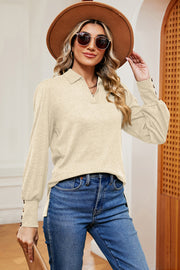 Cream buttoned collared blouse with lantern sleeves and button cuffs.
