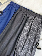 Printed comfort jeans in black and blue with drawstring waist and paisley pattern detail.