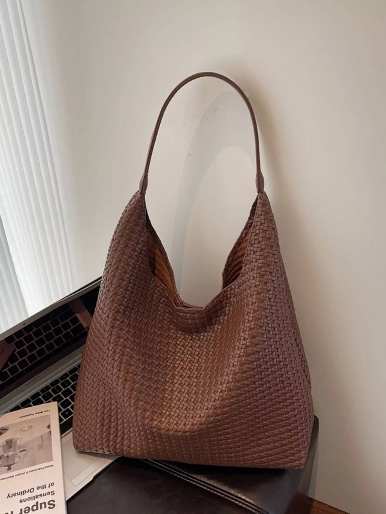 Brown woven straw texture tote bag with a single strap and open top.