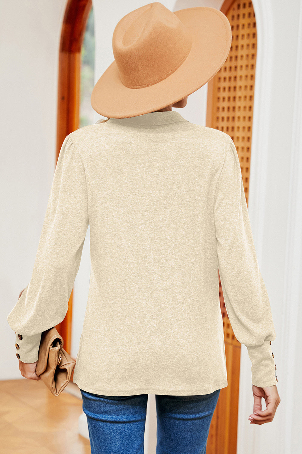Cream buttoned blouse with lantern sleeves and button cuffs.