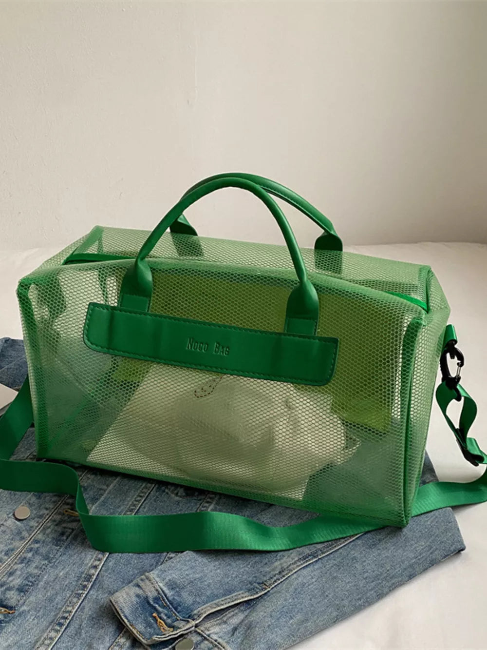 Green mesh travel bag with green straps and handles, clear PVC accents.