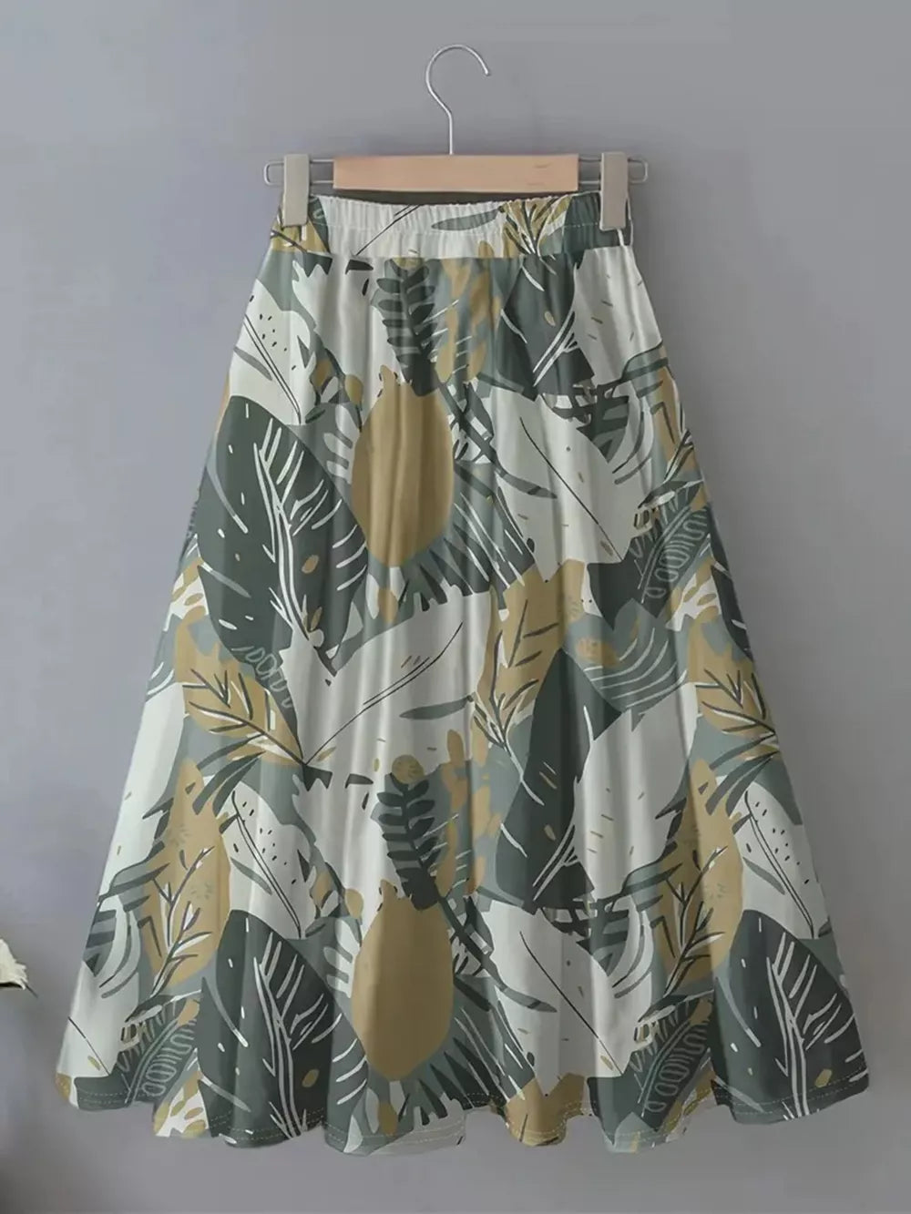 A-line skirt with elastic waist and abstract leaf print in green, olive, and apricot.