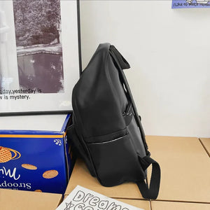 Black leather backpack with front pocket and zipper detail