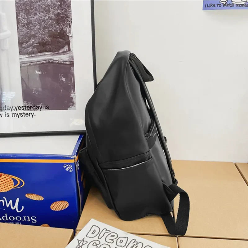 Black leather backpack with front pocket and zipper detail