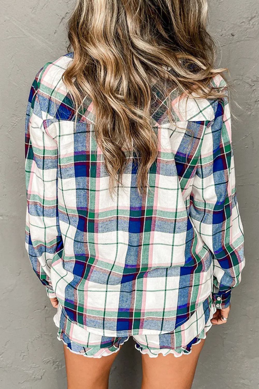 Plaid pajama set with ruffled hem shorts and long sleeve top.