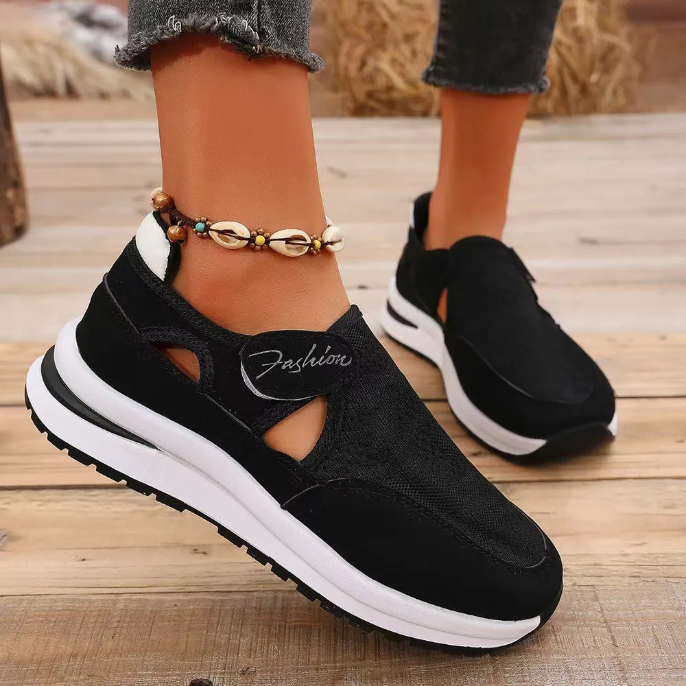 Black mesh platform slip-on sneakers with cutout detail and white sole.