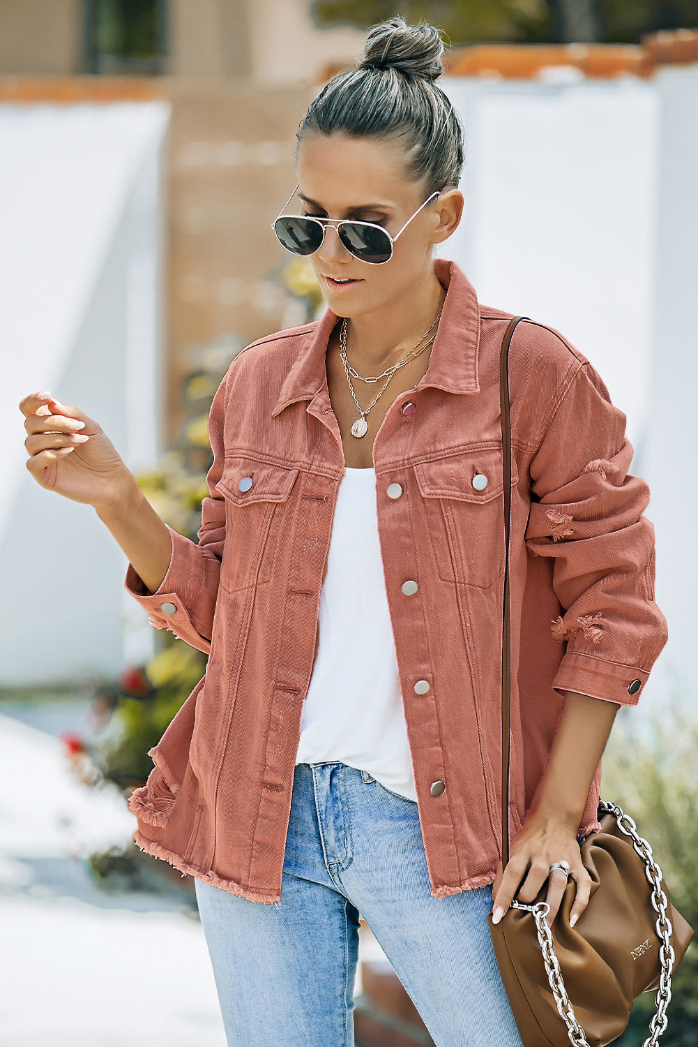 Salmon distressed denim trucker jacket with frayed hem and cuffs.