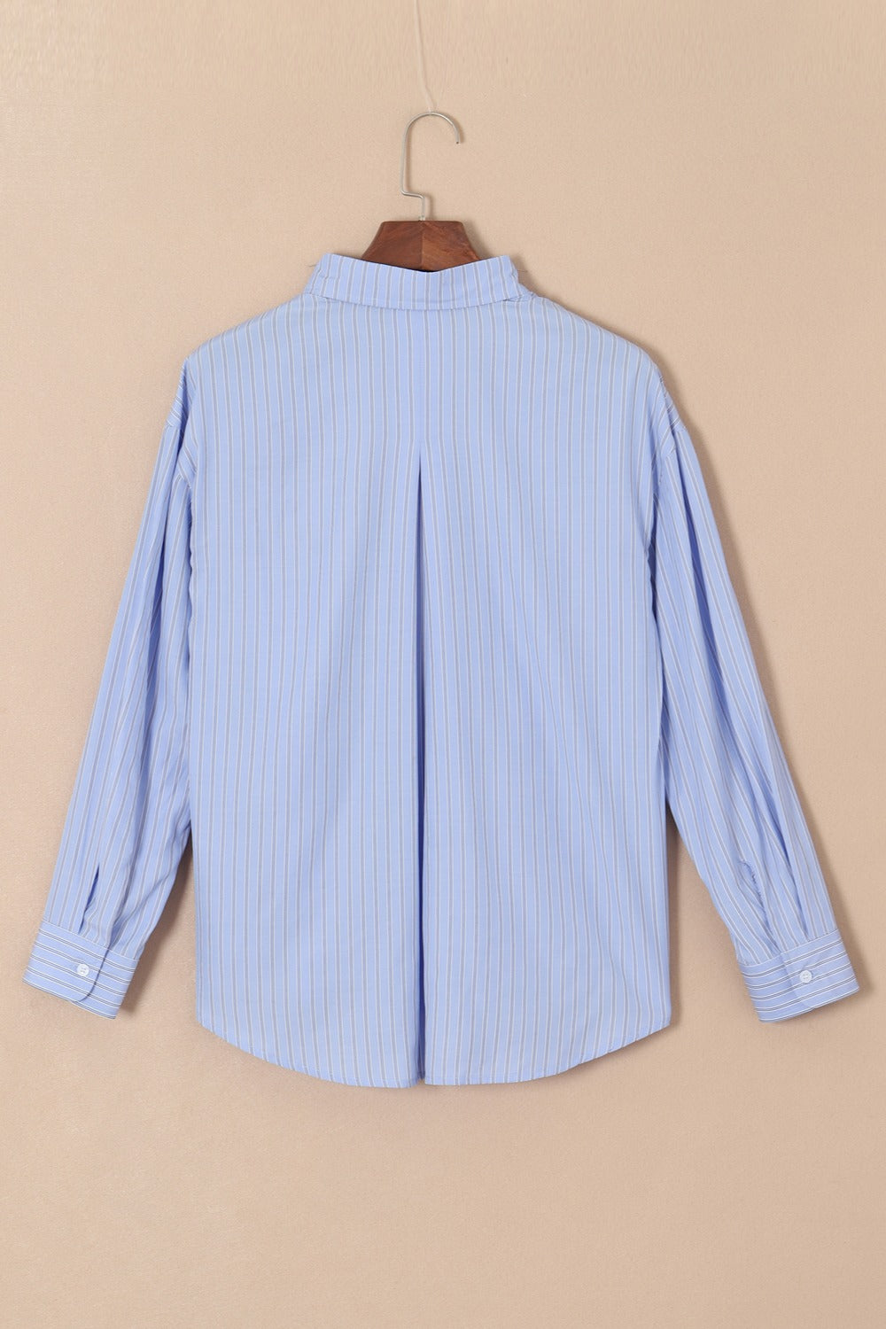 Oversized light blue stripe oxford shirt with buttoned cuffs and back pleat detail.