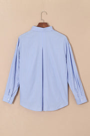 Oversized light blue stripe oxford shirt with buttoned cuffs and back pleat detail.