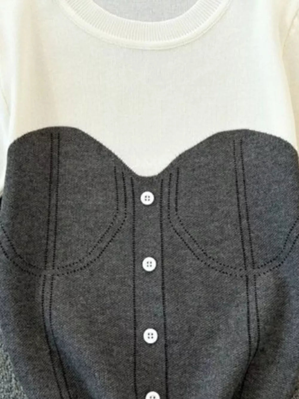 Color block knit t-shirt in white with gray bustier detail and white buttons.