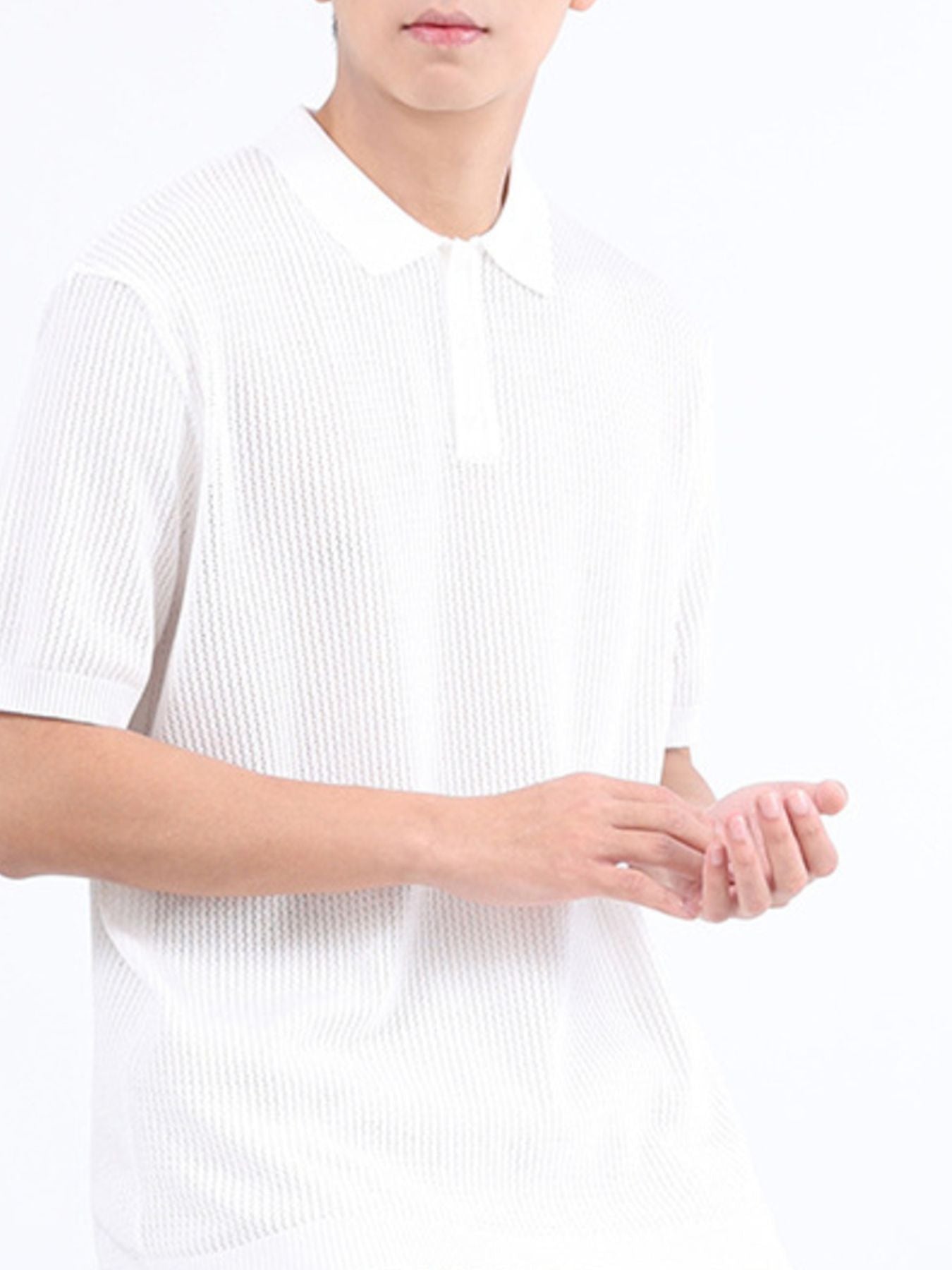 White textured knit polo shirt with classic collar and short sleeves.
