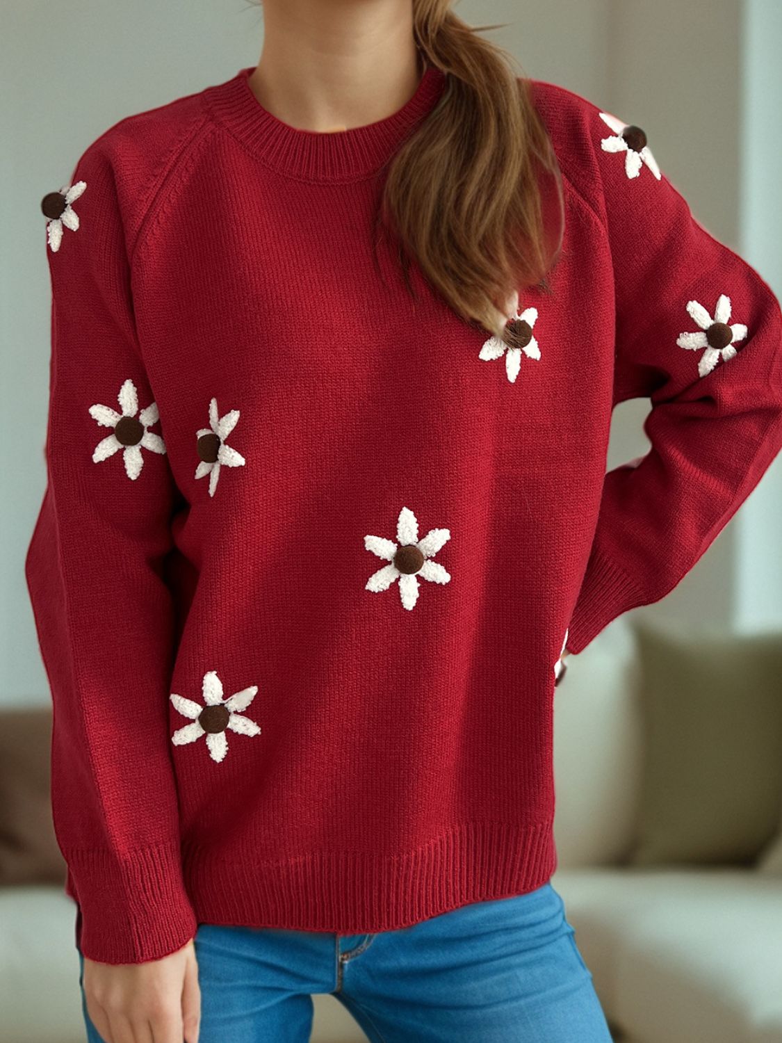 Burgundy knit sweater with embroidered white floral details and a crew neck.