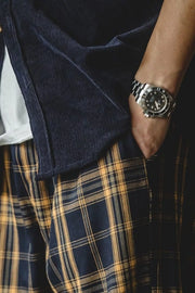 Men's plaid sweatpants in navy and mustard yellow, relaxed fit, with a corduroy jacket detail.