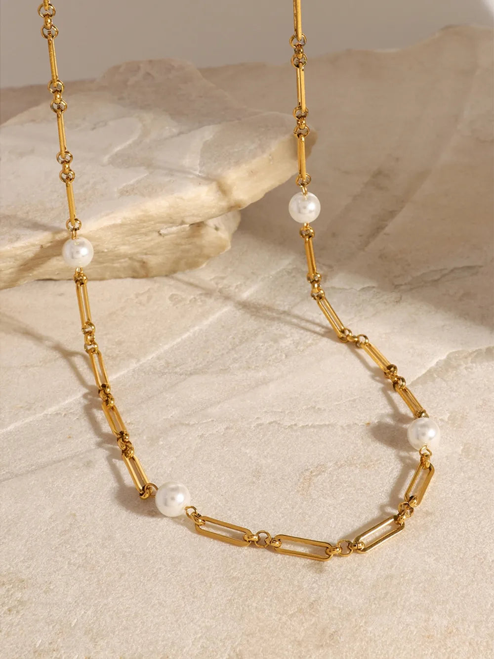 Gold two-tone pearl link necklace with elongated oval chain links and round pearls.