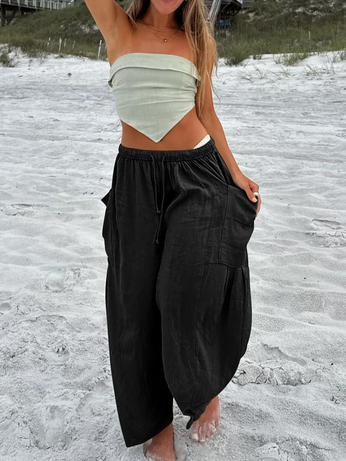 Black linen balloon trousers with cargo pockets and drawstring waist.