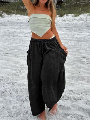 Black linen balloon trousers with cargo pockets and drawstring waist.