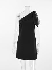 Black asymmetrical mini dress with a bow detail on the single shoulder strap.