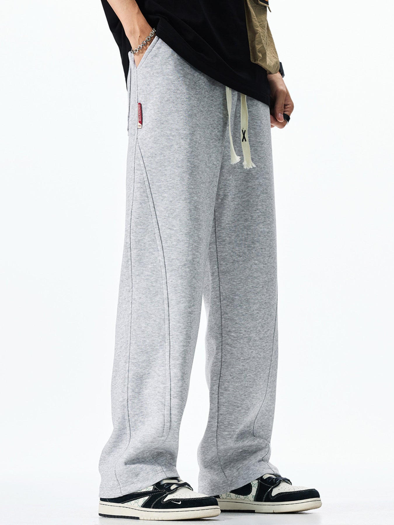 Men's grey casual drawstring sweatpants with loose fit and contrast stitching.
