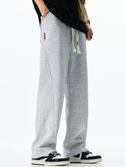 Men's grey casual drawstring sweatpants with loose fit and contrast stitching.