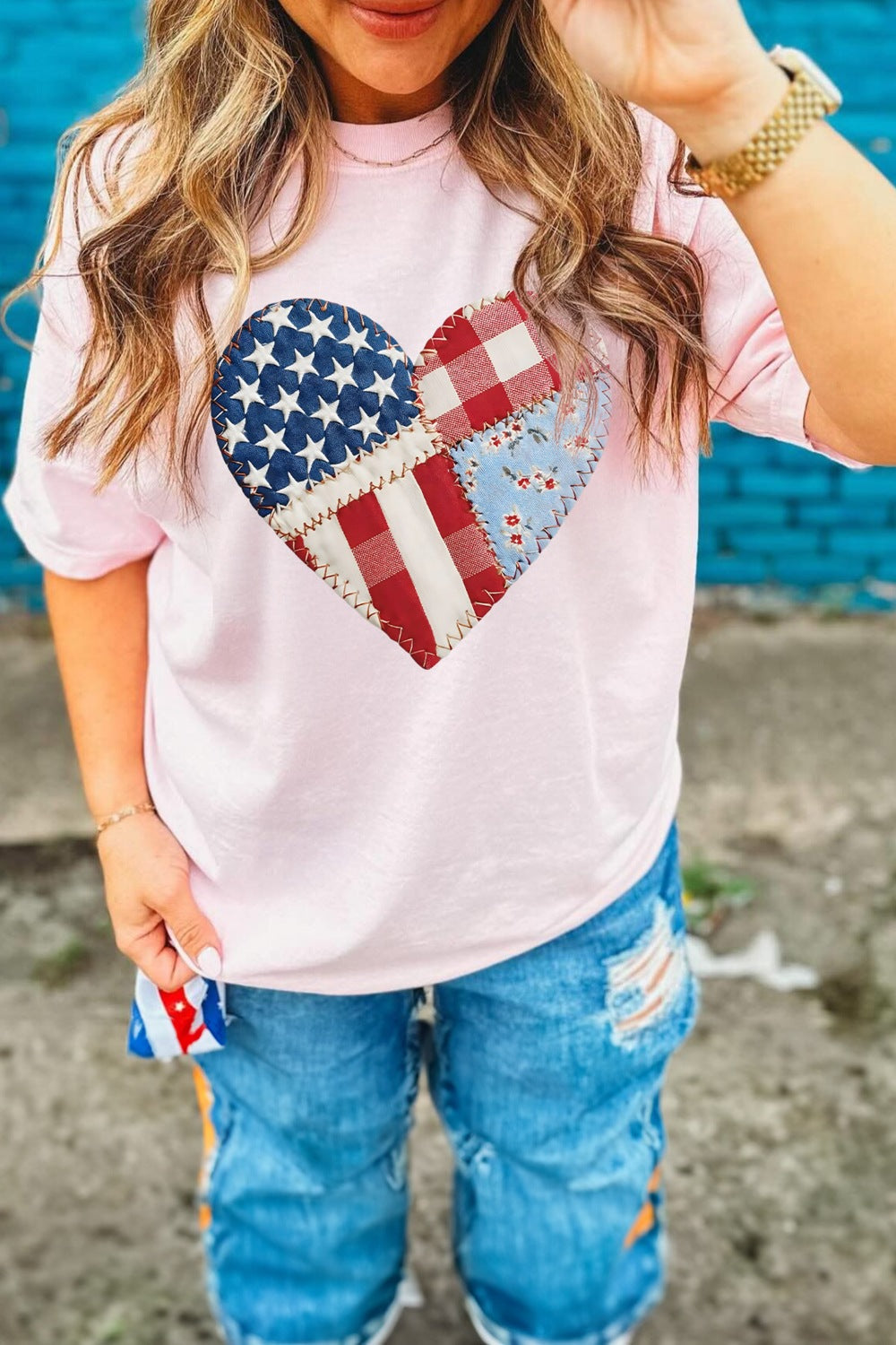 Pink t-shirt with a patriotic patchwork heart graphic on the chest.