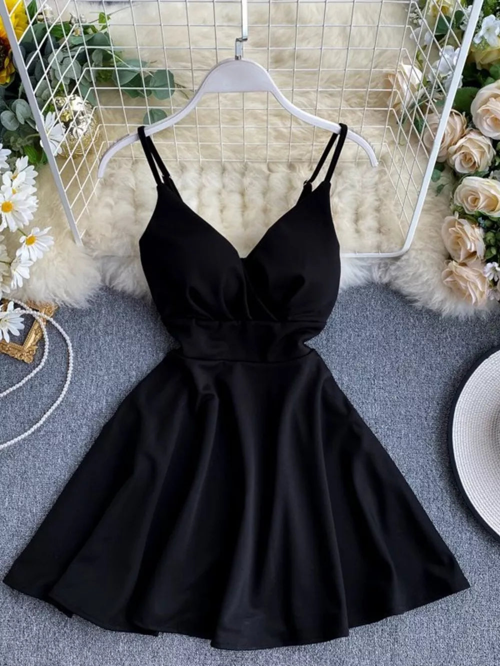 Black V-neck spaghetti strap mini dress with adjustable straps and a flared skirt.