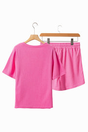 Hot pink waffle knit loungewear set with a short sleeve top and elastic waist shorts.
