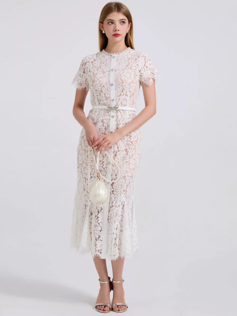White floral lace mermaid dress with short sleeves, pearl buttons, and a jeweled belt.