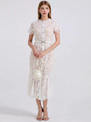 White floral lace mermaid dress with short sleeves, pearl buttons, and a jeweled belt.