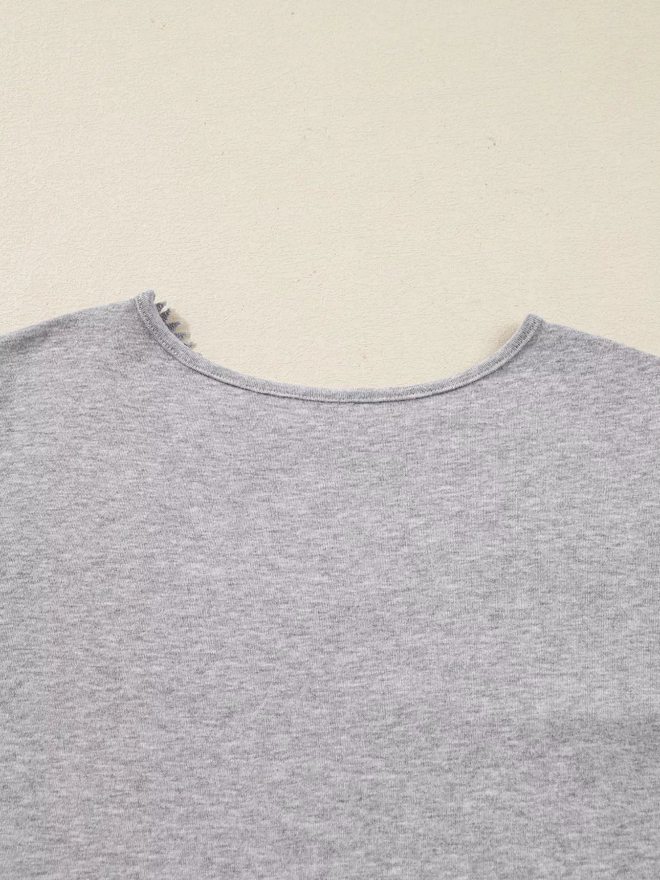 Gray ribbed knit long-sleeve top with delicate lace trim at the neckline.