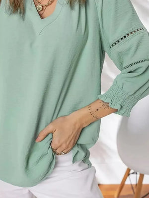 Light green polyester blouse with smocked cuffs and lace detail on sleeves.