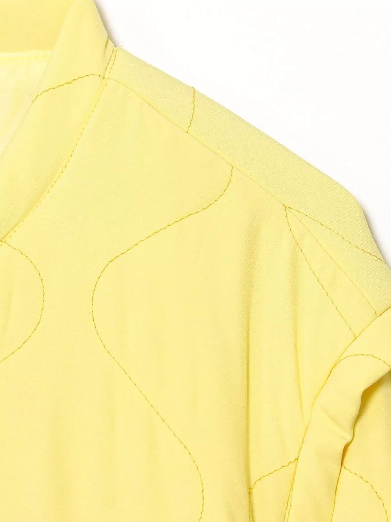 Yellow quilted puffer jacket with wave stitching detail on shoulder and sleeve.
