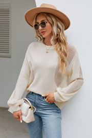 Cream knit sweater with slit details and crew neck, styled with jeans.