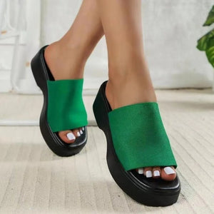 Green platform knit slide sandals with a thick black sole.