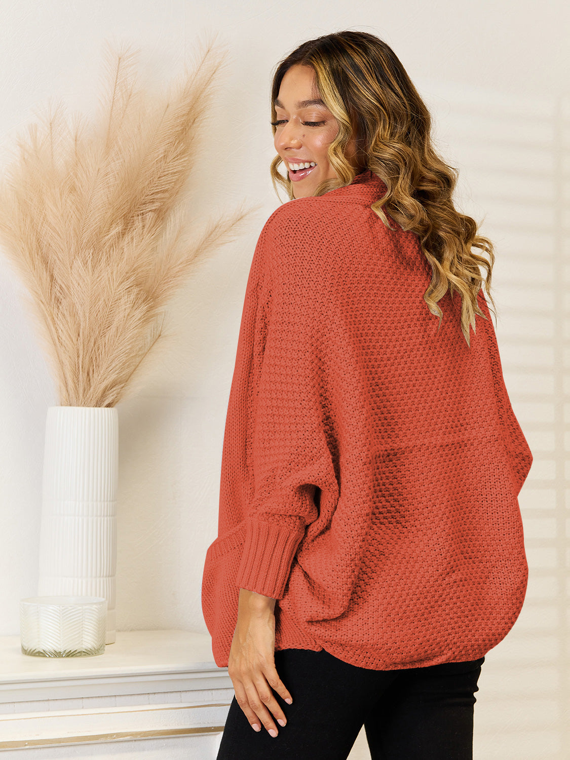 Cocoon knit cardigan in rust with dolman sleeves and ribbed cuffs.