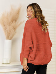 Cocoon knit cardigan in rust with dolman sleeves and ribbed cuffs.