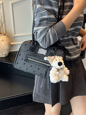Sophisticated polka dot shoulder bag in black with a playful teddy bear charm.