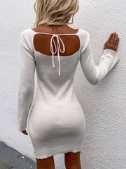 White ribbed knit mini dress with long sleeves and a back tie detail.