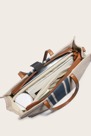 Nautical canvas tote bag in khaki with blue stripes and leather trim, open to show interior.