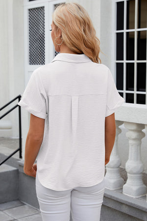White textured short sleeve collared shirt with a button front and cuffed sleeves.