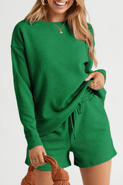 Dark green textured geometric loungewear set with long sleeve crewneck top and drawstring shorts.