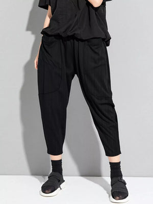 Black pinstripe harem maternity pants with pockets and elastic waist.