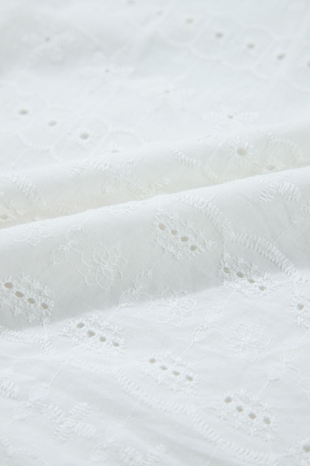 White eyelet blouse with floral embroidery and ruffle sleeve detail