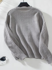 Gray cable knit cardigan with textured sleeves and ribbed cuffs.