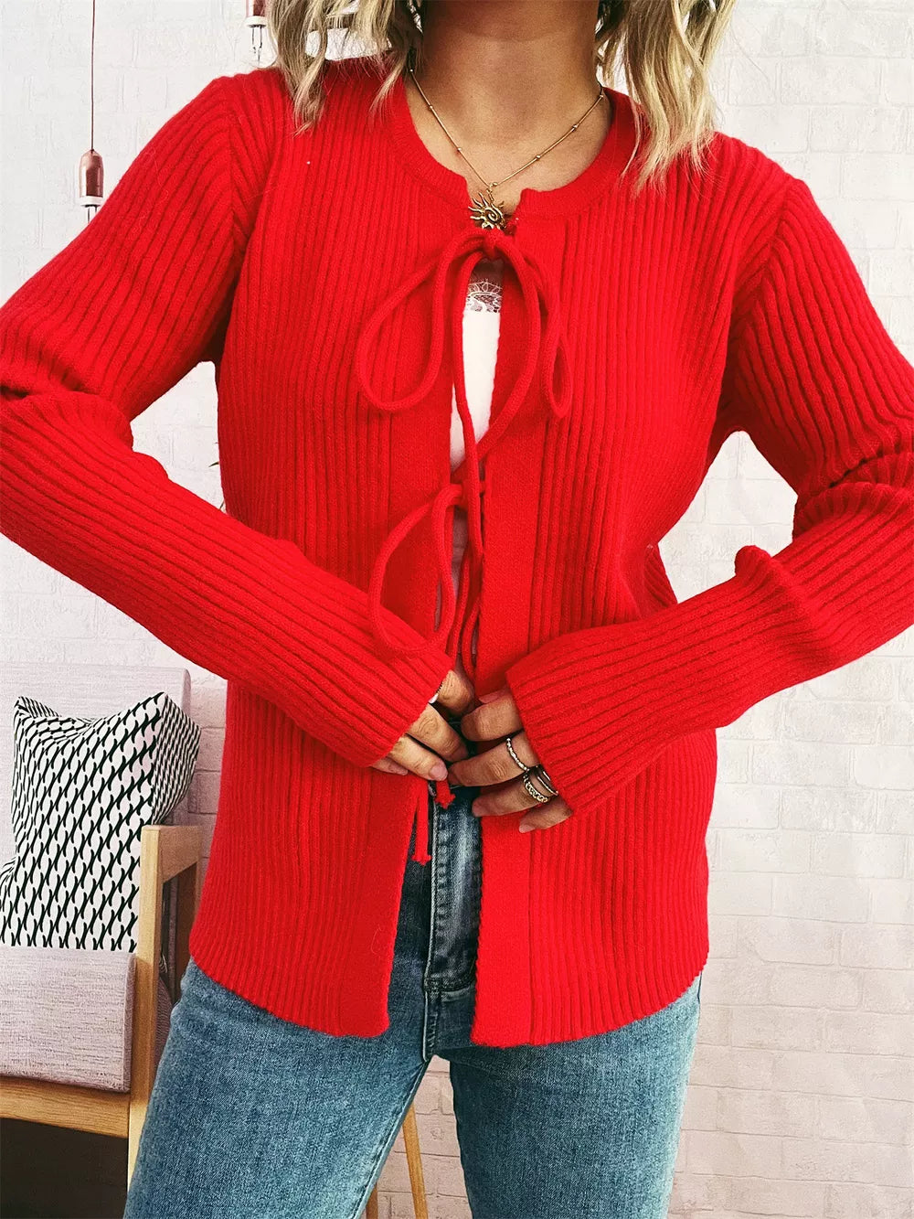 Red ribbed tie-front cardigan with cuffed sleeves and a white cami.
