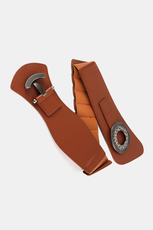 Caramel wide elastic belt with sculpted alloy buckle and decorative ring detail.