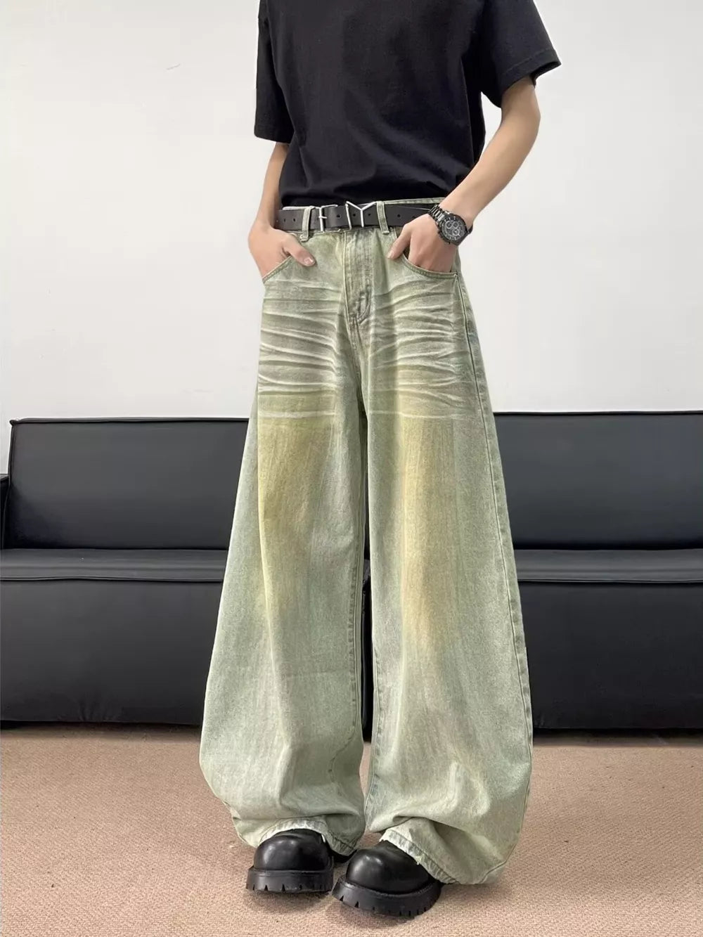 Men's oversized light wash jeans with creasing and yellowing details.