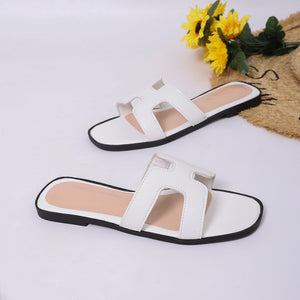 Chic H-strap open-toe sandals in white with contrast stitching and black soles.